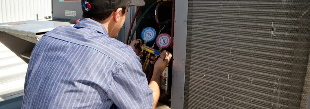 HVAC technician servicing a condenser unit in Rockmart