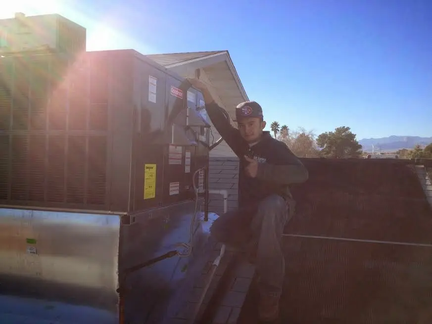 HVAC technician performing Air Duct Cleaning on a rooftop unit in Rockmart